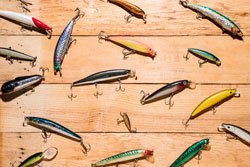 Colorful fishing lures on wooden desk 